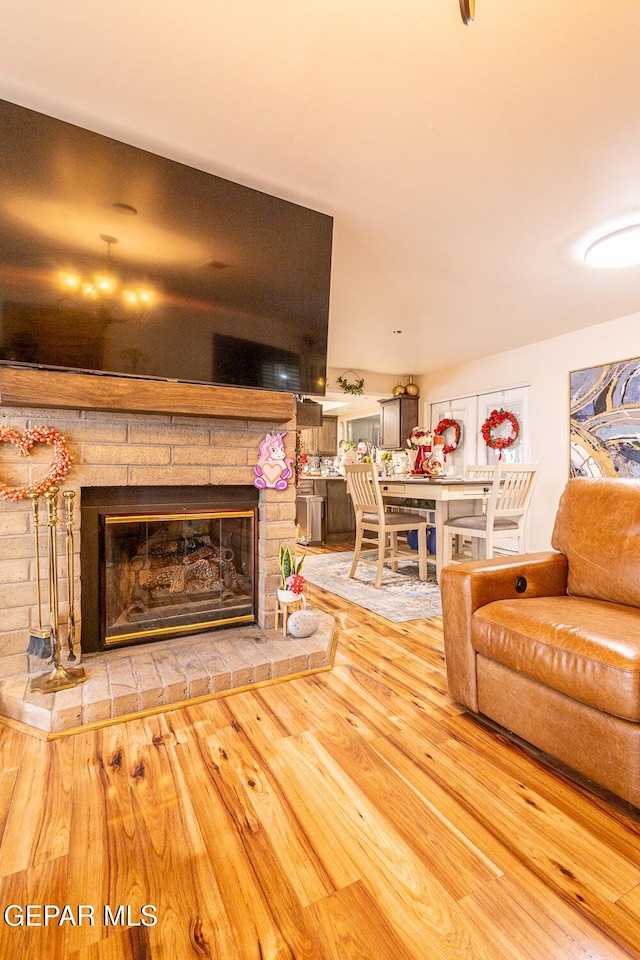 living room featuring a stone fireplace and hardwood / wood-style floors