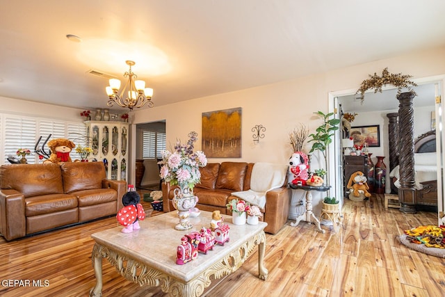 living room with a notable chandelier and light hardwood / wood-style floors