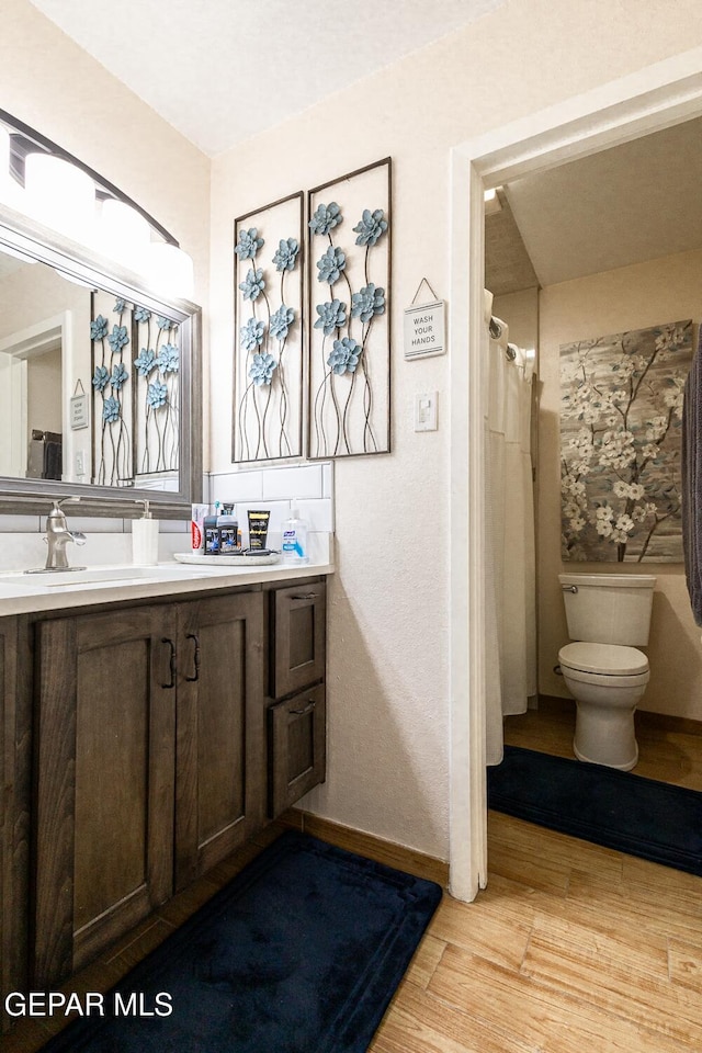 bathroom featuring hardwood / wood-style flooring, vanity, and toilet