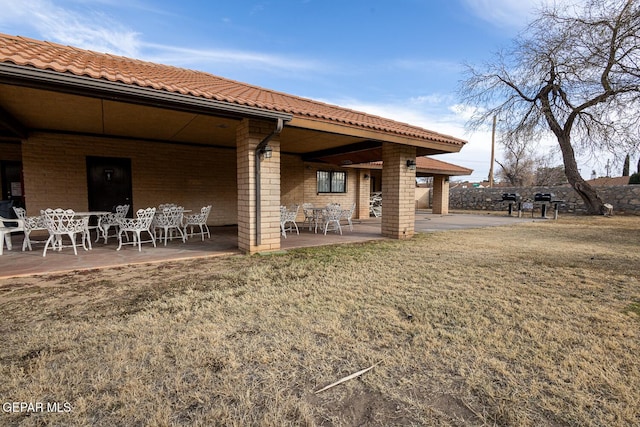 back of property featuring a patio and a lawn