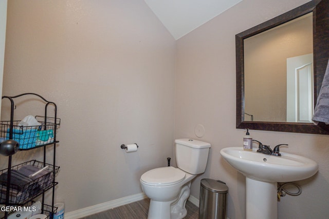 bathroom with hardwood / wood-style flooring, lofted ceiling, and toilet