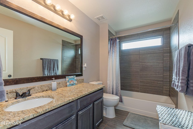 full bathroom featuring vanity, shower / tub combo, and toilet