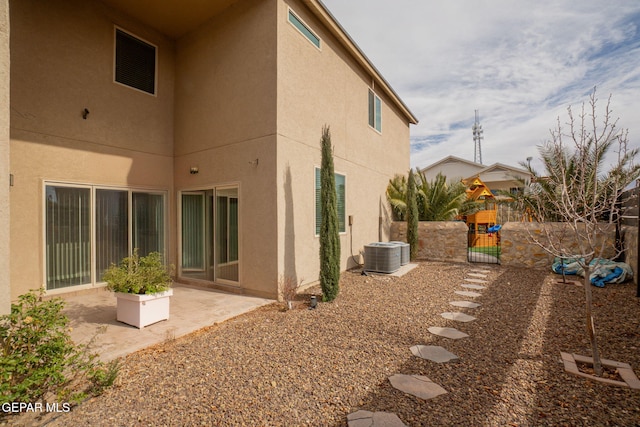 rear view of house with a patio and central AC