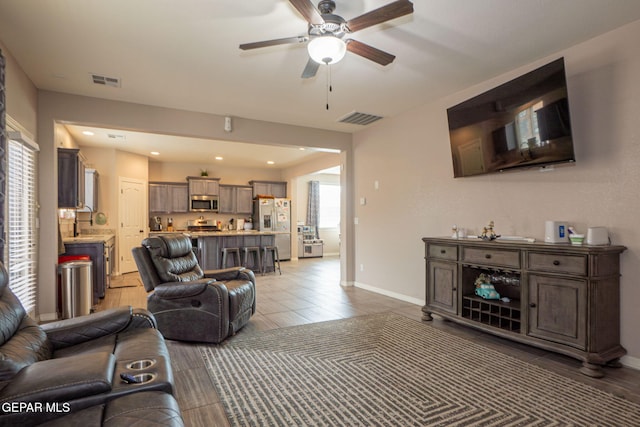 living room with ceiling fan and sink