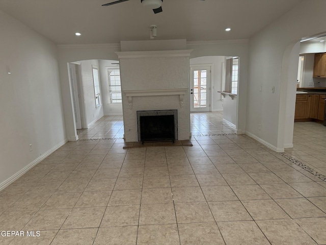 unfurnished living room with crown molding, ceiling fan, and light tile patterned floors