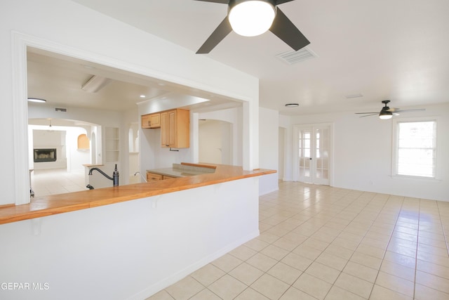 kitchen featuring french doors, light brown cabinetry, sink, light tile patterned floors, and ceiling fan