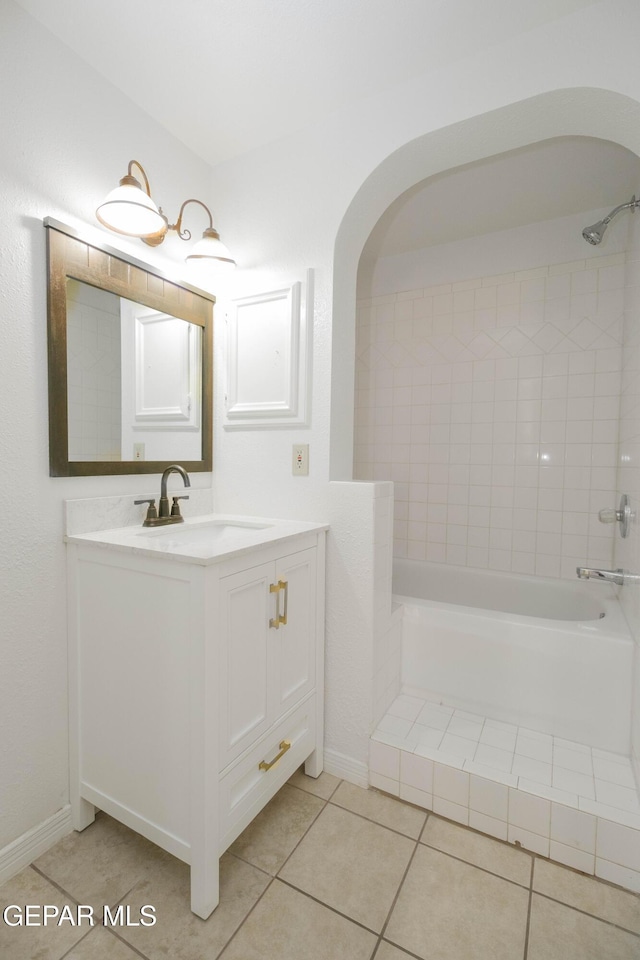 bathroom with tile patterned flooring, vanity, and tiled shower / bath combo