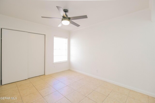 unfurnished bedroom with ceiling fan, a closet, and light tile patterned floors