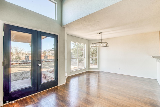 interior space with dark wood-type flooring, a textured ceiling, and french doors