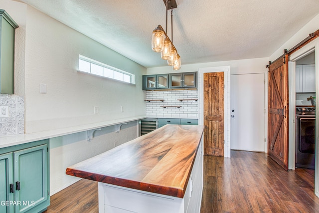 kitchen with dark hardwood / wood-style floors, beverage cooler, decorative backsplash, hanging light fixtures, and a barn door