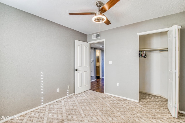 unfurnished bedroom with ceiling fan, carpet floors, a closet, and a textured ceiling