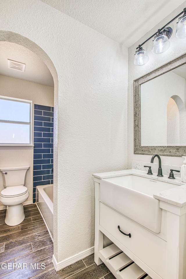 bathroom featuring vanity, a textured ceiling, and toilet