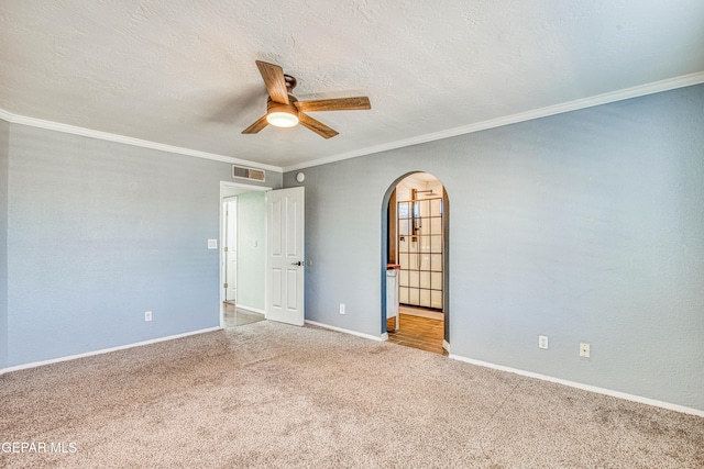 carpeted spare room featuring ceiling fan, ornamental molding, and a textured ceiling