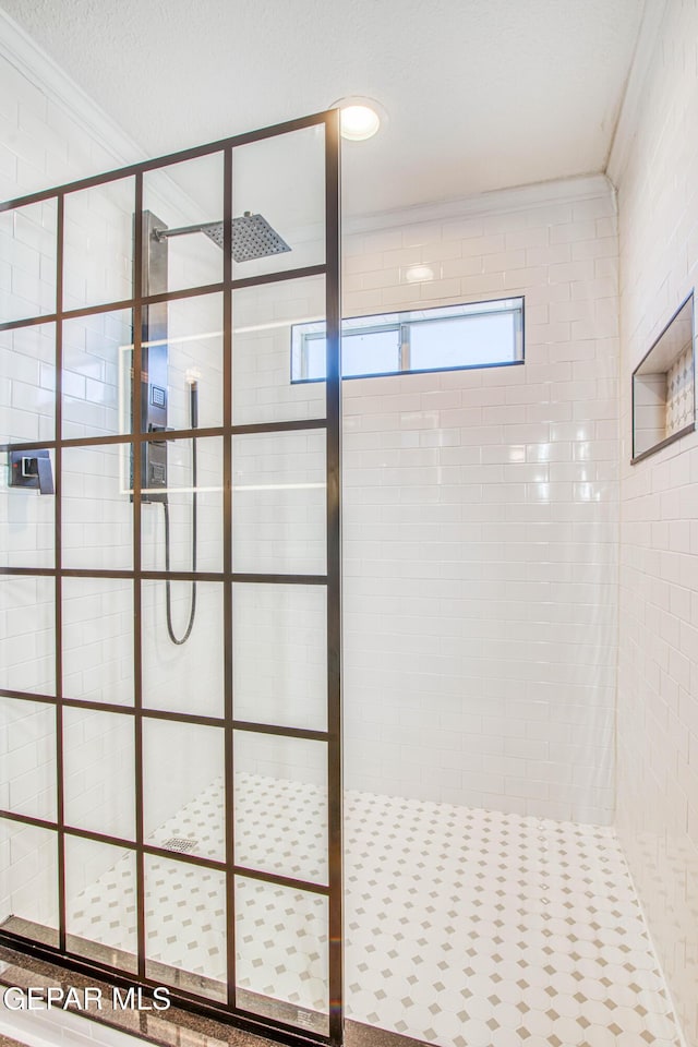 bathroom featuring crown molding and tiled shower