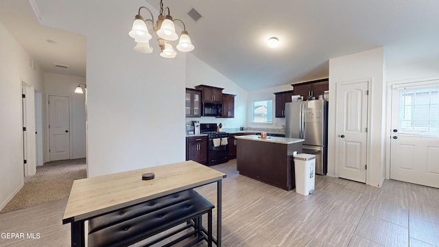 kitchen with hanging light fixtures, dark brown cabinets, a center island, black appliances, and vaulted ceiling