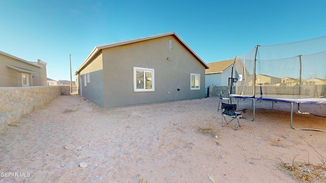 rear view of property with a trampoline