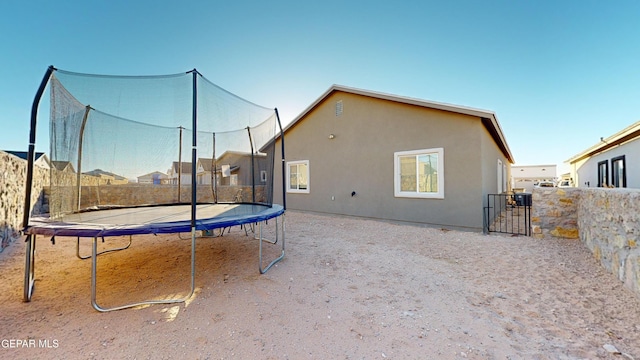 back of property featuring a trampoline