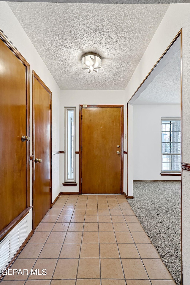 interior space with light tile patterned floors and a textured ceiling