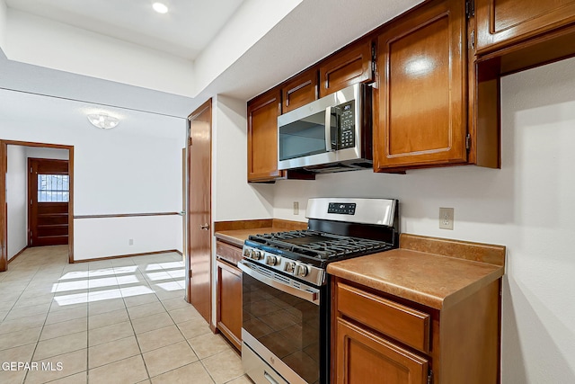 kitchen featuring stainless steel appliances and light tile patterned flooring