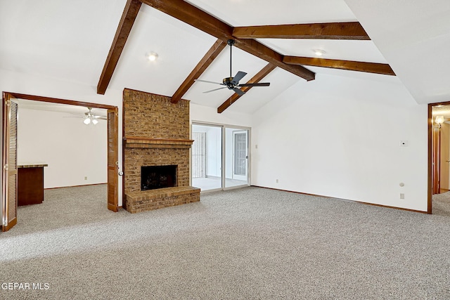 unfurnished living room featuring a brick fireplace, carpet floors, beamed ceiling, and ceiling fan