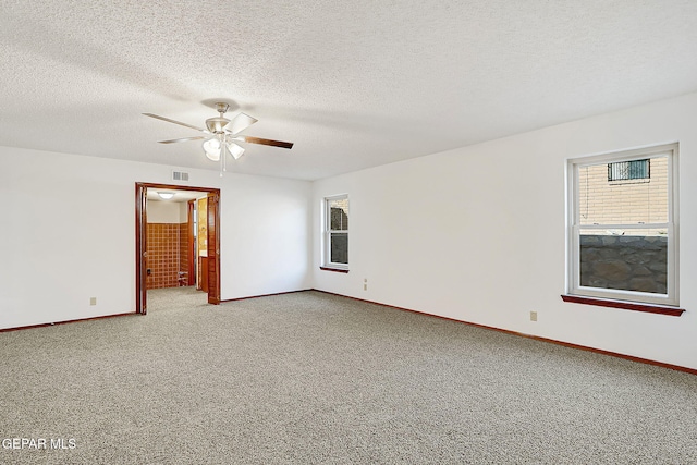 carpeted spare room featuring ceiling fan and a textured ceiling