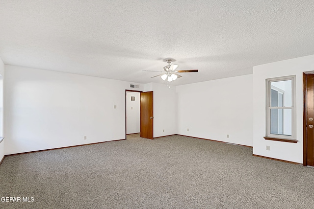 spare room with a textured ceiling, ceiling fan, and carpet