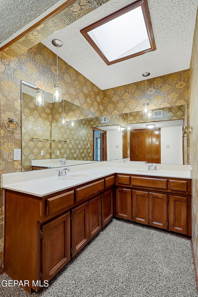 bathroom featuring vanity, a textured ceiling, and a skylight