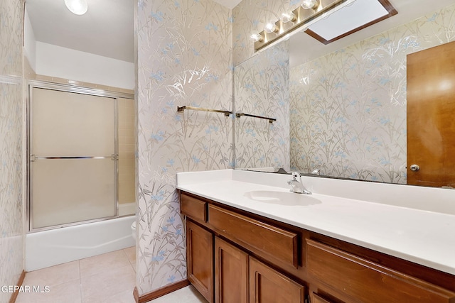 bathroom with bath / shower combo with glass door, tile patterned floors, and vanity