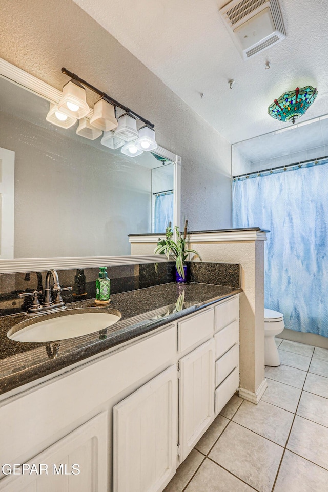 bathroom featuring lofted ceiling, vanity, toilet, tile patterned floors, and a shower with shower curtain