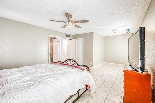 tiled bedroom featuring ceiling fan and a textured ceiling