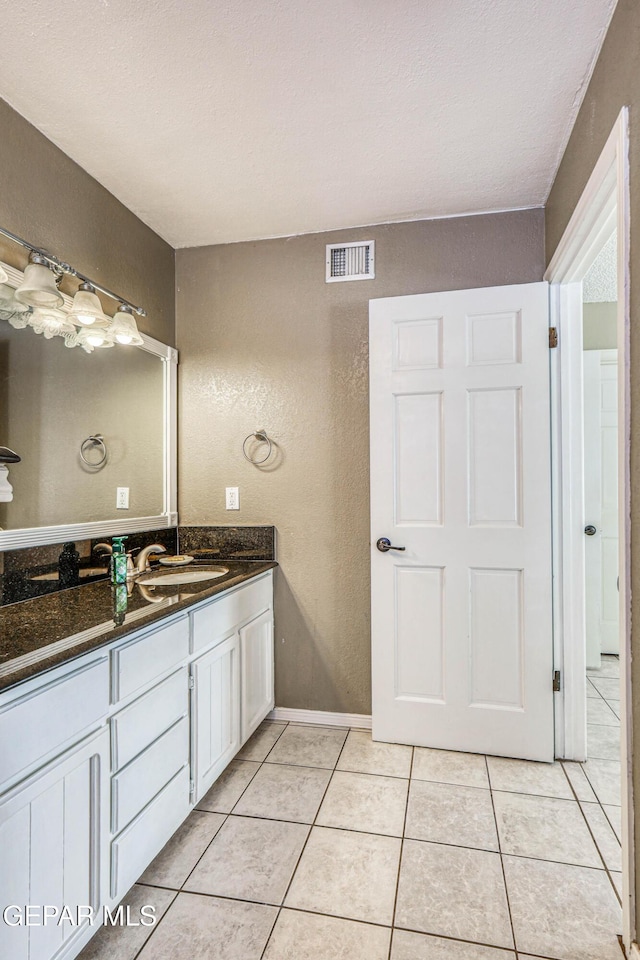 bathroom featuring tile patterned floors, vanity, and a textured ceiling