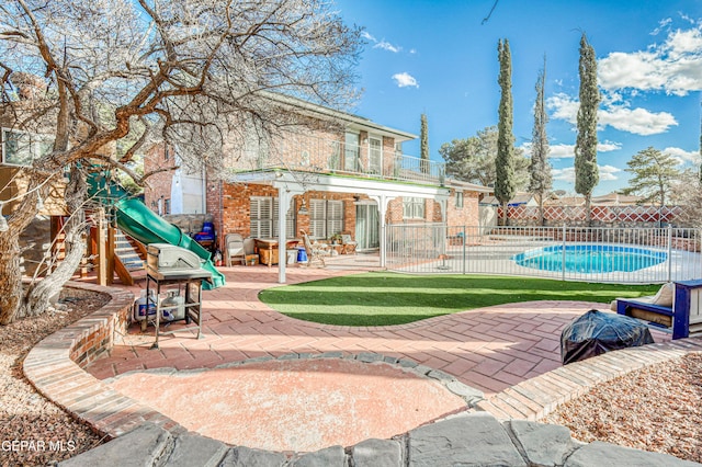 exterior space with a fenced in pool, a patio area, an outdoor structure, and a playground