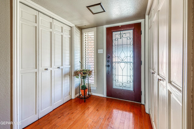 foyer entrance with hardwood / wood-style flooring and a textured ceiling