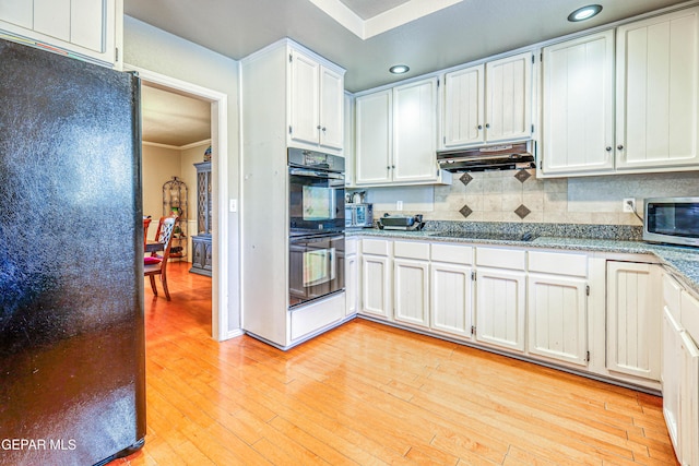 kitchen with crown molding, black appliances, light stone countertops, decorative backsplash, and white cabinets