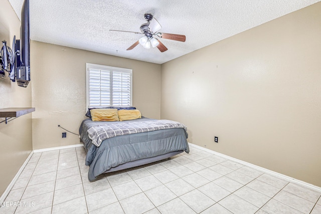 bedroom with ceiling fan, light tile patterned flooring, and a textured ceiling