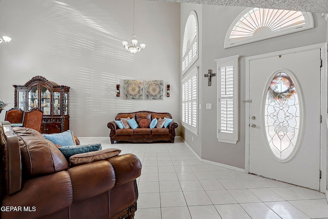 entryway featuring light tile patterned floors, a notable chandelier, and a towering ceiling