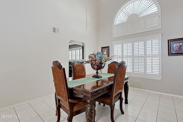 dining room with light tile patterned flooring and a high ceiling