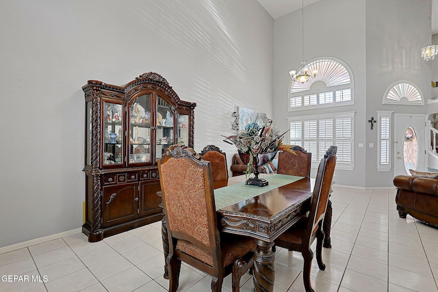 dining room with light tile patterned flooring, a high ceiling, and a notable chandelier