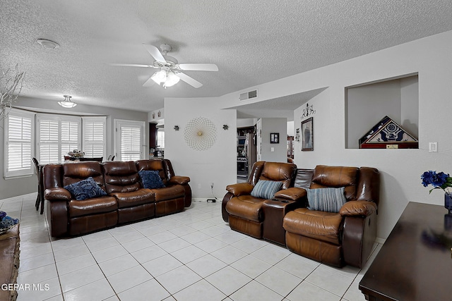 living room featuring light tile patterned floors, a textured ceiling, and ceiling fan