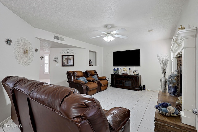 tiled living room featuring ceiling fan and a textured ceiling