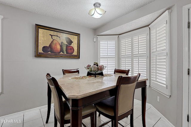 dining space with light tile patterned floors and a textured ceiling