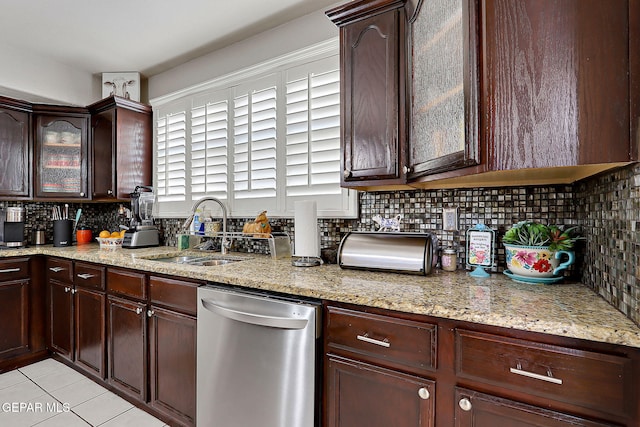 kitchen featuring stainless steel dishwasher, dark brown cabinetry, light stone countertops, and sink