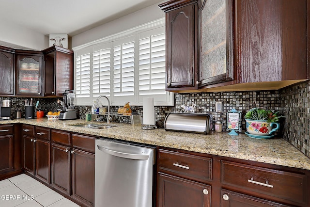 kitchen with dishwasher, light stone countertops, sink, and backsplash