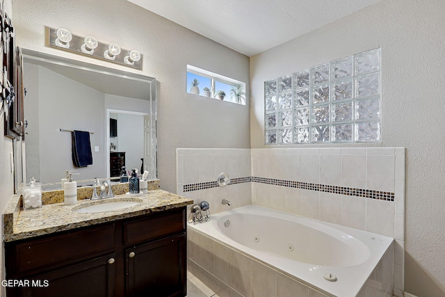 bathroom with vanity and tiled tub