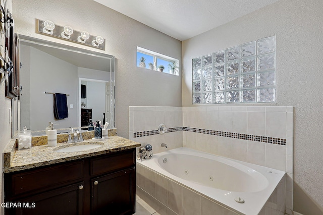 bathroom featuring vanity and a relaxing tiled tub