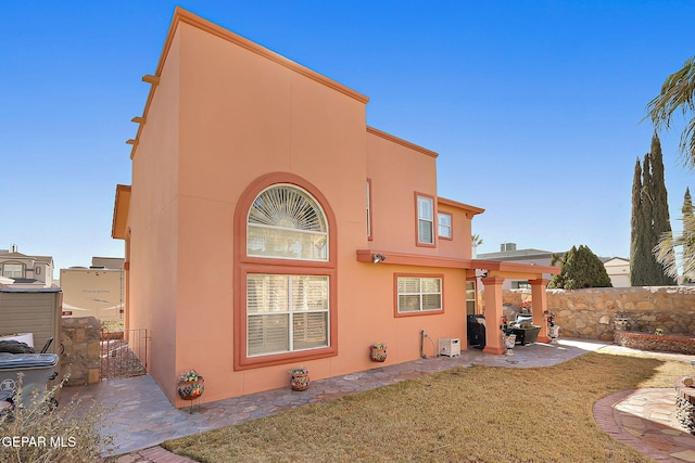 back of property featuring a yard and a patio