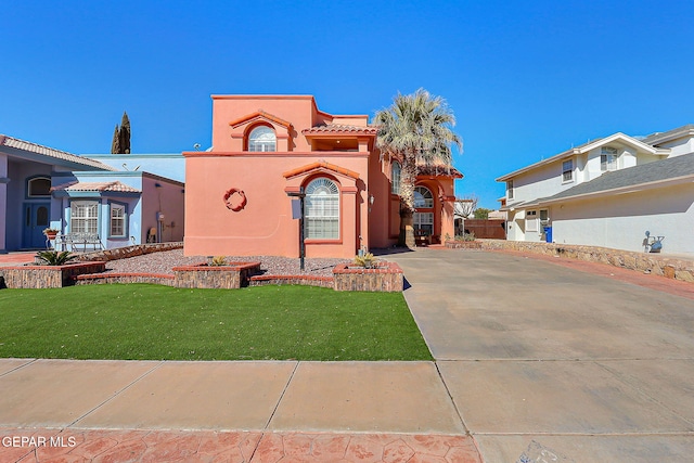 mediterranean / spanish-style home with a front yard