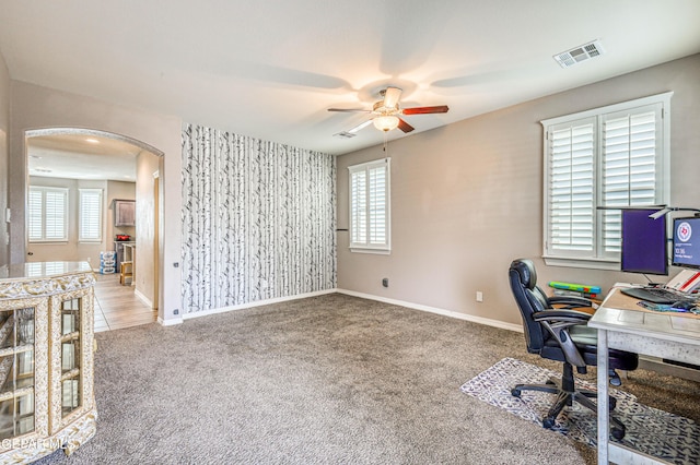 carpeted office space featuring ceiling fan