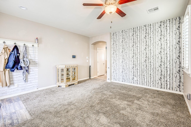 unfurnished room with ceiling fan and carpet