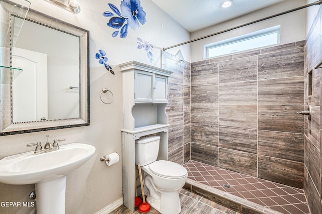 bathroom featuring toilet and tiled shower